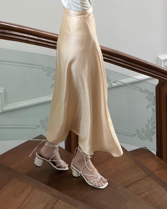 一個人穿著 the.lookbook.select 的芭蕾長裹身裙和白色繫帶涼鞋站在木樓梯上。