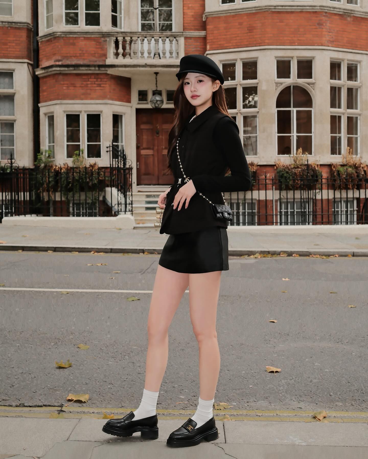 穿著 the.lookbook.select 的 Diana Vest Coat 🖤新品優惠至 12 月 5 日,一位女士在紅磚建築前的城市人行道上散發著毫不費力的 法式精緻風格。.