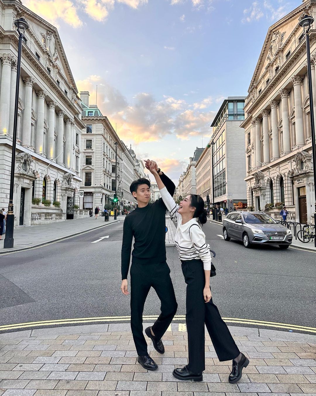 兩個人在倫敦街頭跳舞，穿著 the.lookbook.select 舒適的 Danielle 針織毛衣，展現簡約時尚的輪廓。