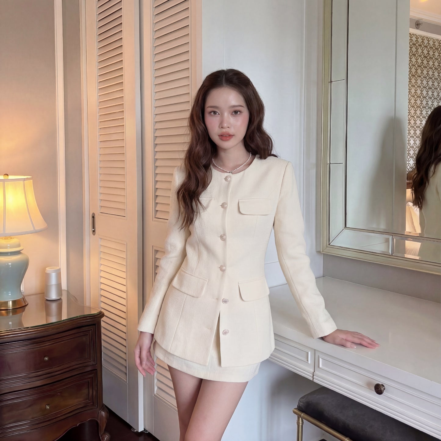 一位身穿 the.lookbook.select's All White Set 🖤新品優惠 2件9折的女士站在室內的木質梳妝台和帶鏡子的白色梳妝台附近。.