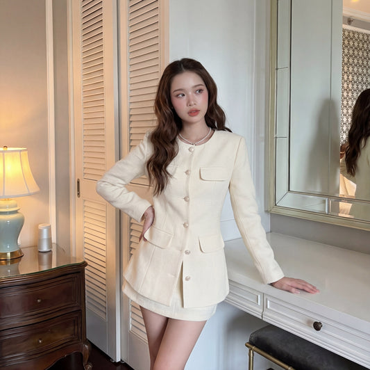 在 the.lookbook.select 的 All White Set 🖤新品優惠 2 件9折中，一位女士站在室內的白色書桌和鏡子旁，附近有一盞燈和木抽屜。.