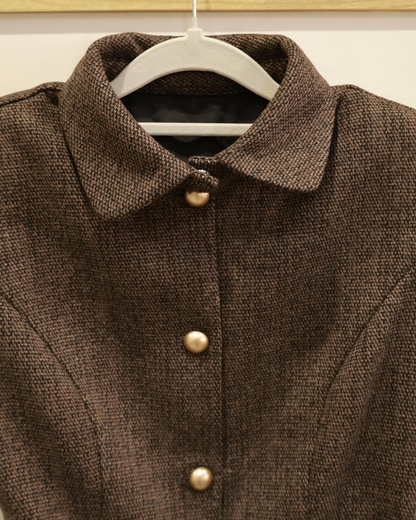 The.lookbook.select的 Moka Tweed Dress 🖤新品優惠2件9折掛在衣架上的特寫，展示其棕色紋理布料、衣領和前襟的三顆金色鈕扣。.