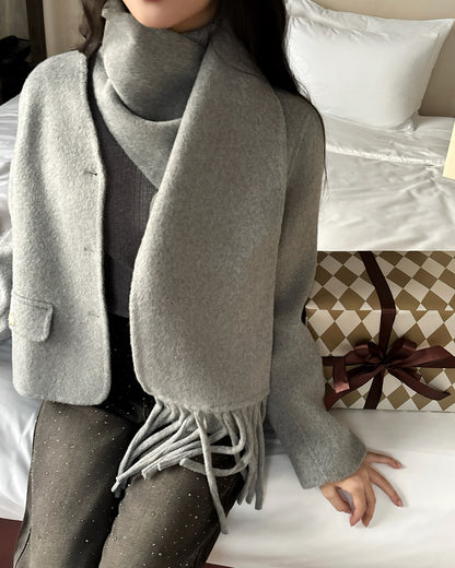 穿著 the.lookbook.select 的 Snow Wool Coat❄️，一個人坐在床上，床邊是一個綁著棕色緞帶的圖案禮盒。.