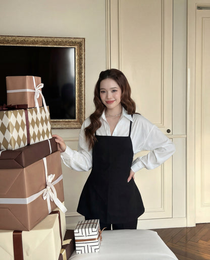 一位穿著 the.lookbook.select 設計的 Moet 褲子套裝的女士，站在室內堆滿包裝禮盒的桌子旁。.