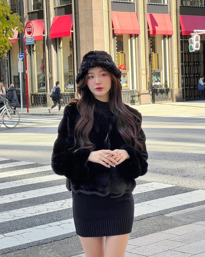 一位女士穿著the.lookbook.select的棉花糖皮草大衣 (附帽子) 走在城市的人行道上，背景是紅色破曉的店面。.