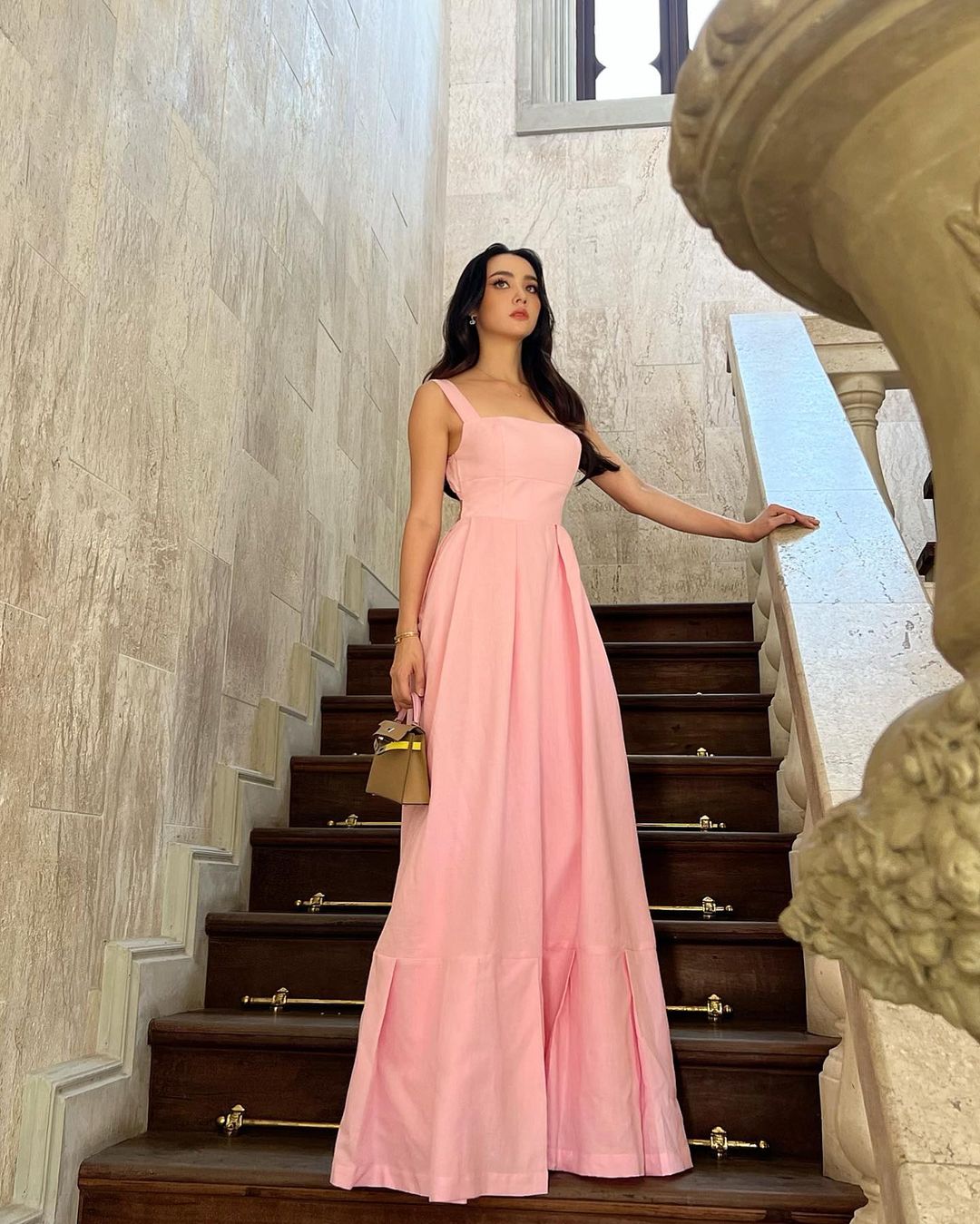 穿著 the.lookbook.select 粉紅色 Leeann 長裙的公主站在樓梯上。